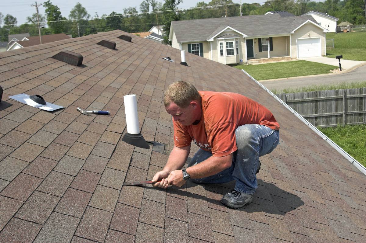 Photo: a roofer replacing shingles